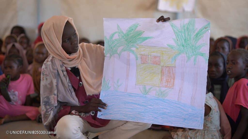 Awatif, 11 ans, montre son dessin à d'autres enfants dans un centre soutenu par l'UNICEF, à Tawila, dans le nord du Darfour au Soudan. © UNICEF/UNI825330/Jamal