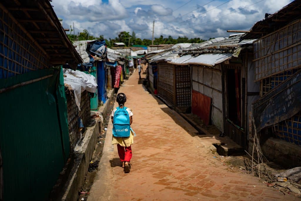 [Bangladesh éducation 2025] Une fillette porte un sac à dos de l'UNICEF dans le camp de Rohingyas à Ukhiya, dans le district de Cox's Bazar. Les élèves du primaire ne peuvent plus aller à l'école en raison de la fermeture des établissements et rares sont ceux qui peuvent encore suivre des cours particuliers pour rattraper leur retard scolaire. © UNICEF/UNI866997/