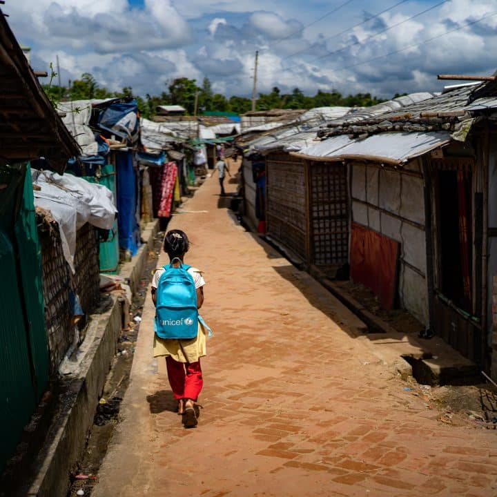 [Bangladesh éducation 2025] Une fillette porte un sac à dos de l'UNICEF dans le camp de Rohingyas à Ukhiya, dans le district de Cox's Bazar. Les élèves du primaire ne peuvent plus aller à l'école en raison de la fermeture des établissements et rares sont ceux qui peuvent encore suivre des cours particuliers pour rattraper leur retard scolaire. © UNICEF/UNI866997/