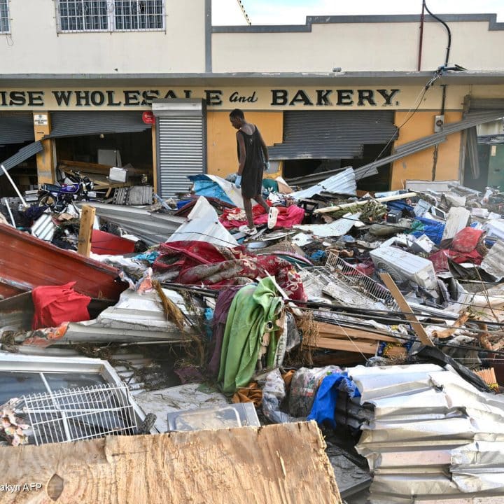 Un jeune homme marche sur les décombres laissés dans la rue après le passage de l'ouragan Melissa, à Black River, en Jamaïque, le 29 octobre 2025. © UNICEF/UNI887332/Makyn AFP