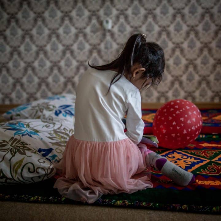 Anelya, age 5, plays in the living room of her family's apartment in Kyzylorda, Kazakhstan on 12 March 2018.  Anelya lost her father in a car accident; her mother, Nurgul, ended up home with two young children in a state of depression. Since 2016, Anelya's family has been supported by patronage nurses, a psychologist and a social worker trained by UNICEF.  'I appreciated Dinara’s [the patronage nurse's] help,' Nurgul says. 'She asked her what kind of help I needed, She taught me so many things: how to read to my children, cook healthy meals.' In Kazakhstan, every second child between 2-14 is subjected to violence in the family. Sometimes it comes in the form of discipline; other occurrences result from domestic abuse. Two-thirds of schoolchildren also experienced or witnessed violence or discrimination by peers or teachers, especially in boarding schools or schools for children with behavioral difficulties. In addition to building the intervention skills of professionals, such as teachers, to work with children to identify and address violence, UNICEF has worked on the ground to eliminate domestic violence through home visits, social worker sessions, local support centers and all other front-line measures to build parental skills. UNICEF also helps all child care-givers to identify suspected cases of violence and report them. Finally, children themselves learn about the safeguards and services to ensure that child victims know where and how to get help. © UNICEF/UN0214785/Babajanyan VII Photo