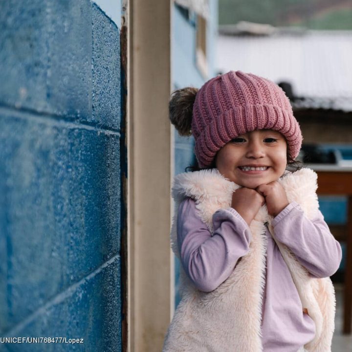 Le 17 mars 2025, à Chiretzaaj, Cobán, au Guatemala, Amani, 3 ans, sourit devant le centre de santé local. © UNICEF/UNI768477/Lopez
