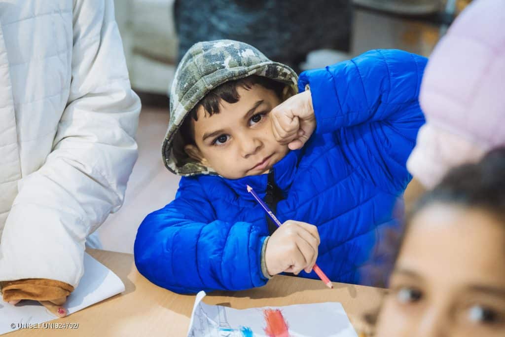 Un enfant pris en photo avec son manteau d'hiver. Des enfants et leurs familles reçoivent des vêtements chauds pour l'hiver lors d'une distribution soutenue par l'UNICEF à Oujgorod, en Ukraine. © UNICEF/UNI824700/