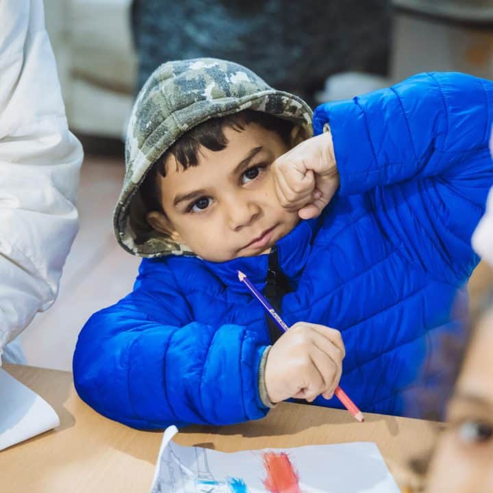 Un enfant pris en photo avec son manteau d'hiver. Des enfants et leurs familles reçoivent des vêtements chauds pour l'hiver lors d'une distribution soutenue par l'UNICEF à Oujgorod, en Ukraine. © UNICEF/UNI824700/