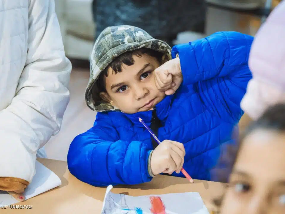 Un enfant pris en photo avec son manteau d'hiver. Des enfants et leurs familles reçoivent des vêtements chauds pour l'hiver lors d'une distribution soutenue par l'UNICEF à Oujgorod, en Ukraine. © UNICEF/UNI824700/