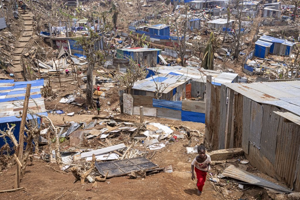 Une fillette marche au milieu des abris endommagés par le cyclone Chido, le plus dévastateur qui ait frappé Mayotte depuis 90 ans. Vahibé, Mayotte, le 24 décembre 2024. © Patrick Meinhardt / AF