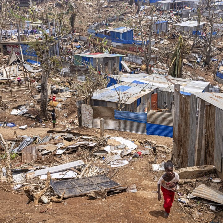 Une fillette marche au milieu des abris endommagés par le cyclone Chido, le plus dévastateur qui ait frappé Mayotte depuis 90 ans. Vahibé, Mayotte, le 24 décembre 2024. © Patrick Meinhardt / AF