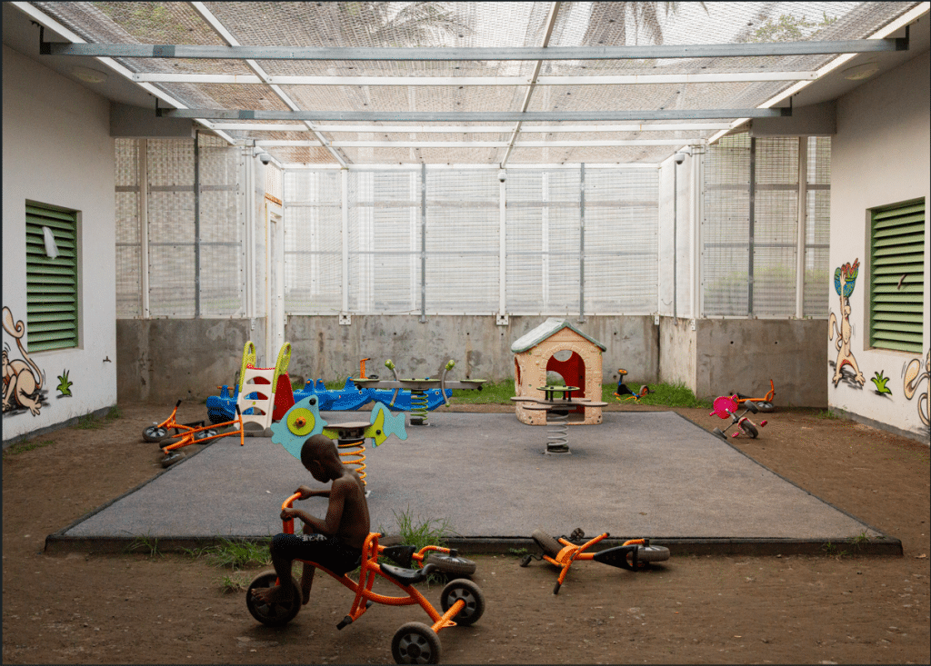 Au Centre de rétention administrative de Pamandzi (CRA), un enfant joue au tricycle dans la cour du secteur réservé aux familles. En 2022, plus de 2 900 enfants y ont été détenus. Pamandzi, Mayotte, le 25 avril 2023. © Morgan Fache
