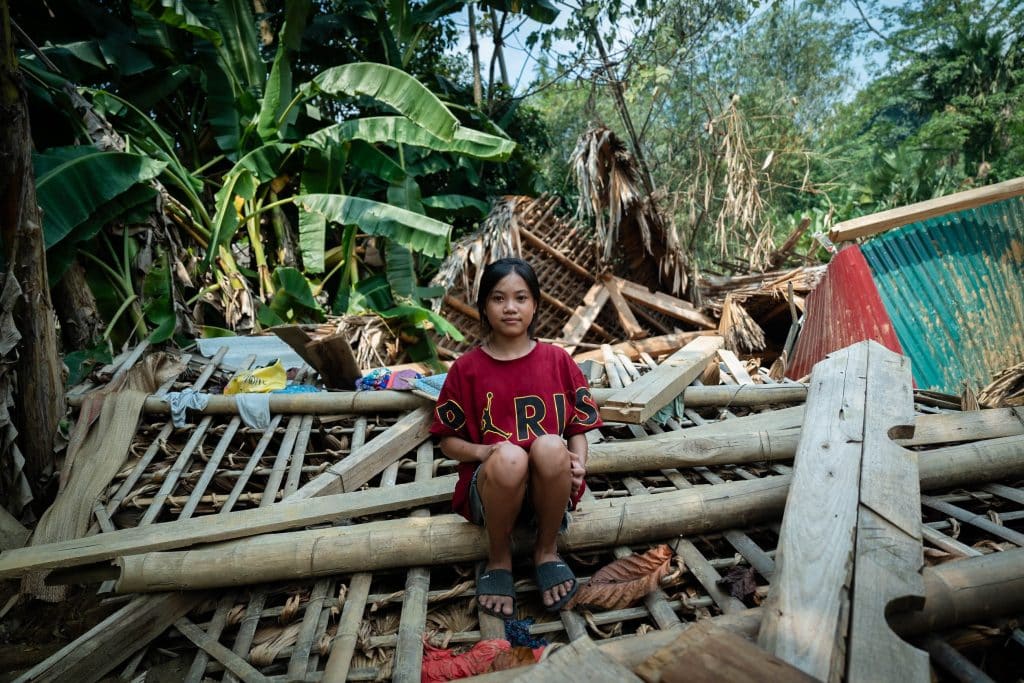 Hoang Thi Tuyet Nhung, 13 ans, est assise sur les ruines de sa maison détruite par un glissement de terrain provoqué par le typhon Yagi dans le village de Thuong, province de Yen Bai. © UNICEF/UNI654509/Le Lijour