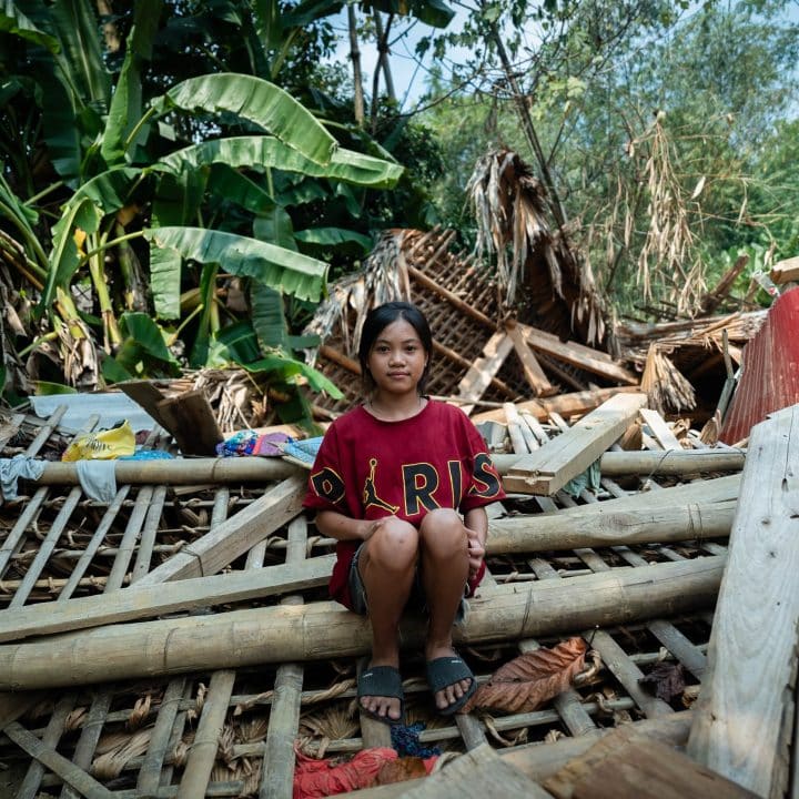 Hoang Thi Tuyet Nhung, 13 ans, est assise sur les ruines de sa maison détruite par un glissement de terrain provoqué par le typhon Yagi dans le village de Thuong, province de Yen Bai. © UNICEF/UNI654509/Le Lijour