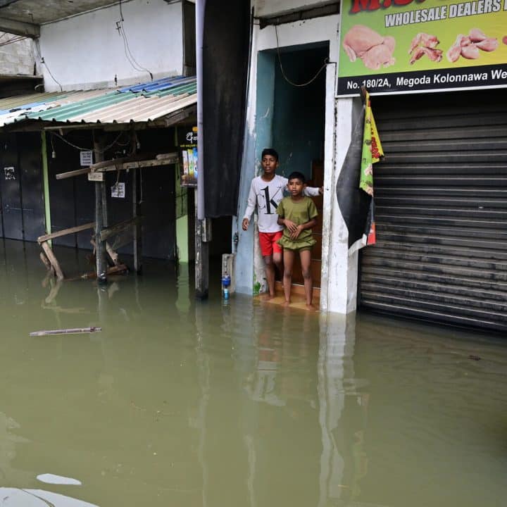 Des garçons bloqués par les inondations, devant leur maison à Wellampitiya, dans la banlieue de Colombo, le 29 novembre 2025. © UNICEF/UNI908499/UNICEF Sri Lanka