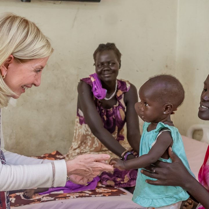 La Directrice générale de l'UNICEF, Catherine Russell, salue une mère et son enfant lors d'une visite à l'hôpital pour enfants Al-Sabah, Soudan du Sud. Décembre 2025. © UNICEF/UNI912493/Nelson