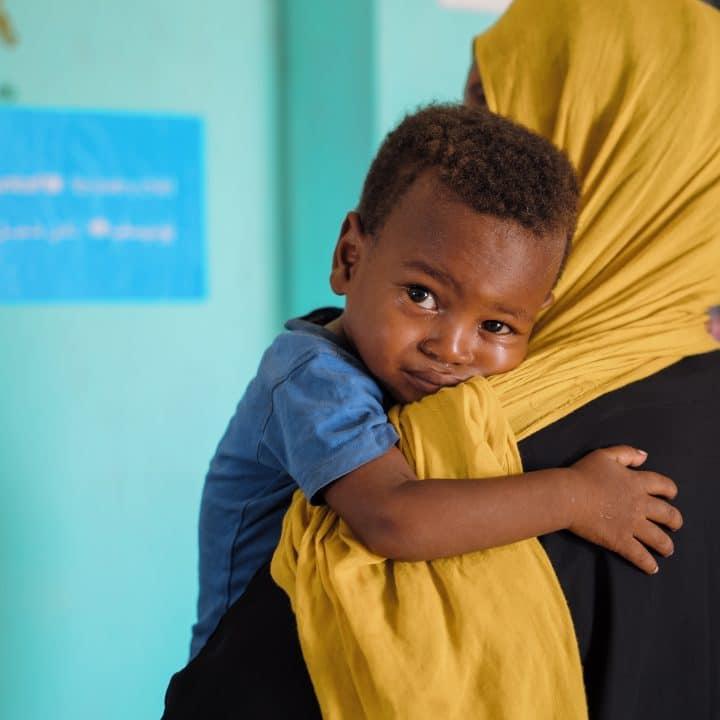 Le 8 décembre 2025, un jeune garçon attend d'être soigné dans un centre de santé soutenu par l'UNICEF sur le site de déplacés internes d'As-Senniya, à Port-Soudan.