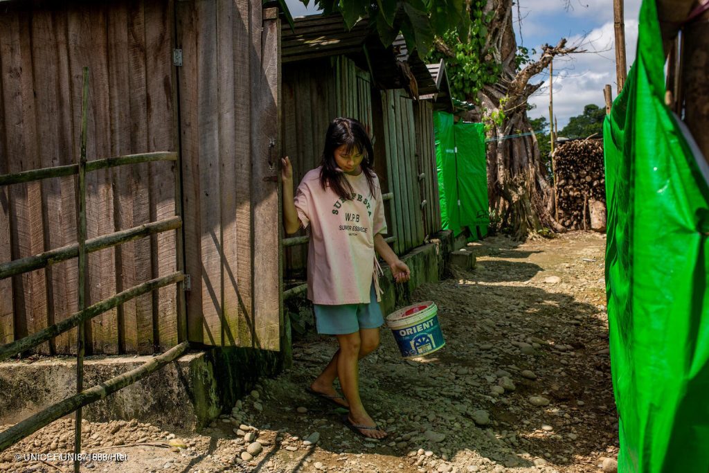 Kyang Sau, 16 ans, transporte de l'eau vers les toilettes communes du camp de déplacés au Myanmar, suite au tremblement de terre ayant frappé le pays. © UNICEF/UNI871888/Htet 